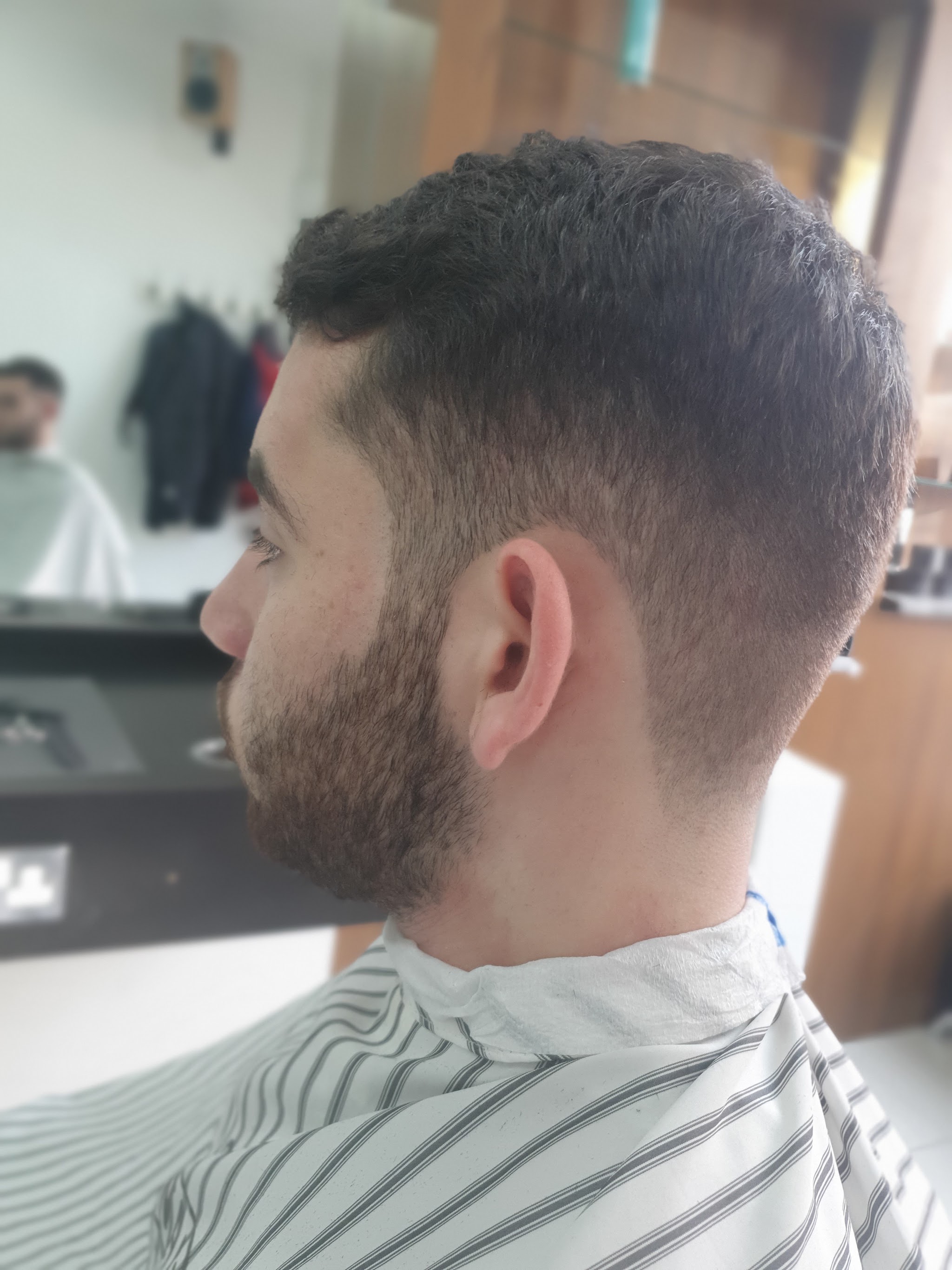 Finished short haircut with a blended fade, photographed inside Fade Station