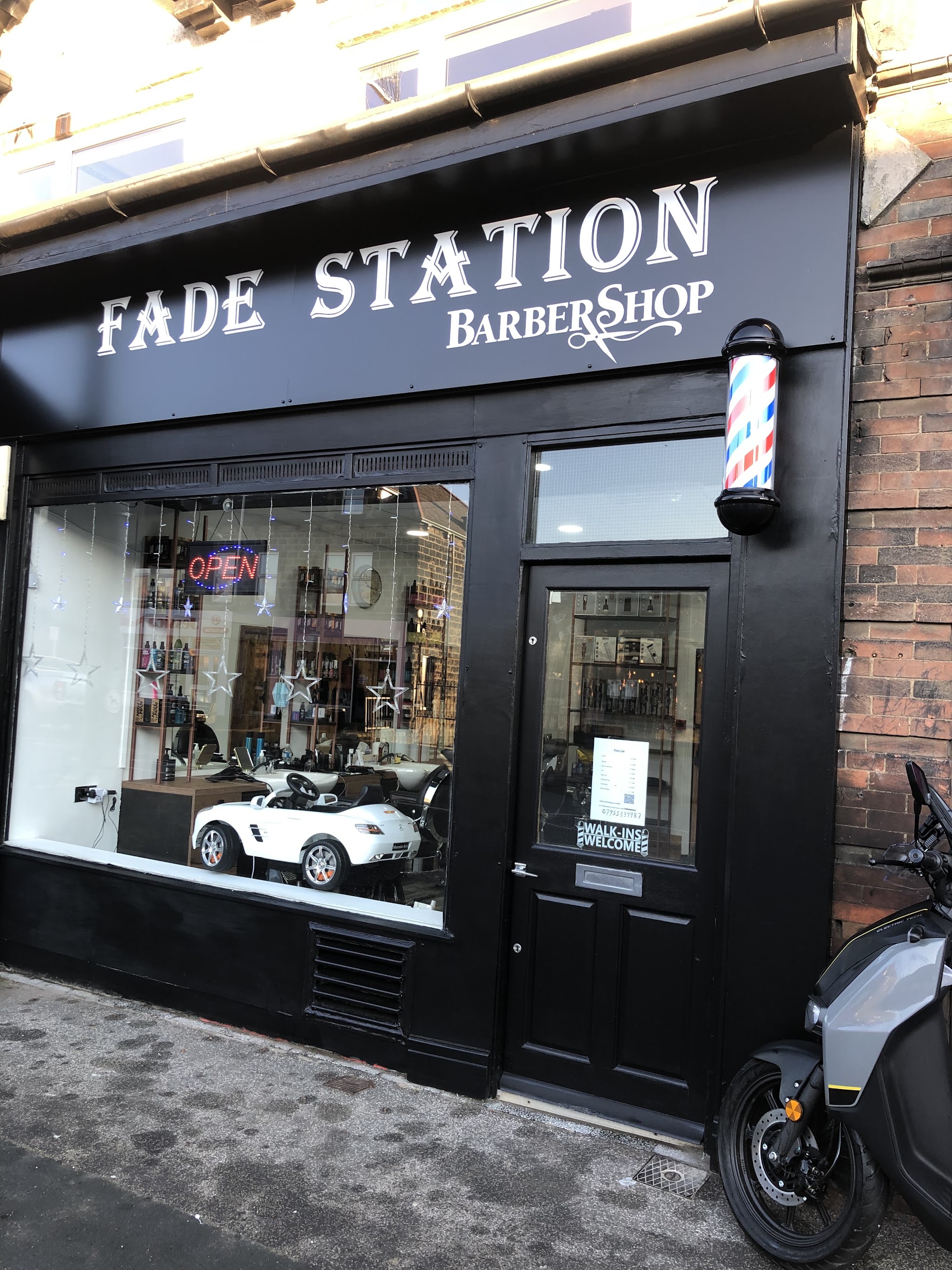 Fade Station's black shopfront at 90 New Road Side, with the children's car chair in the window